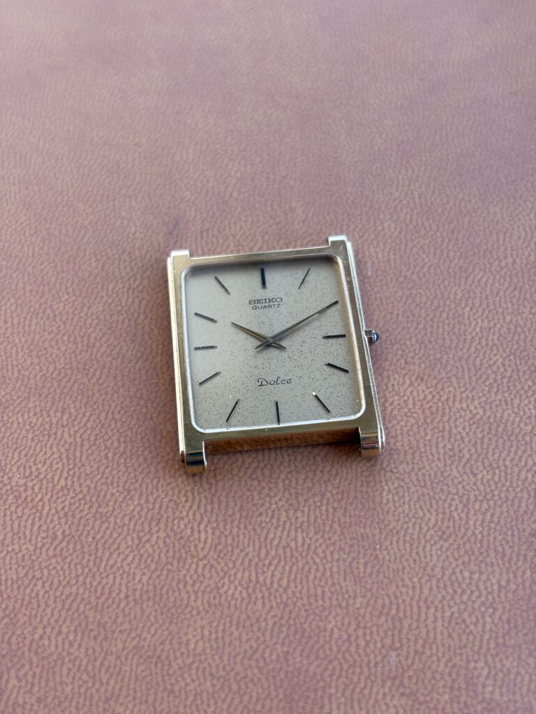 Vintage Seiko Dolce Watch black and gold on brown background. Seiko 6730-5530.