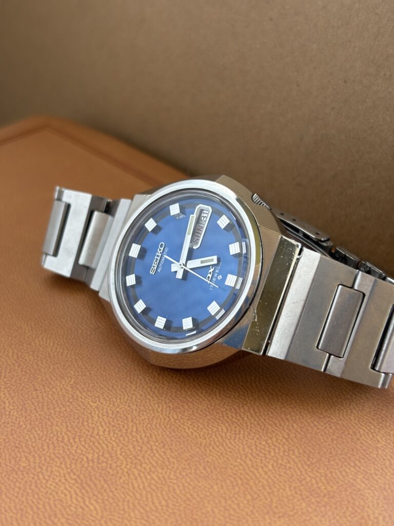 Vintage Seiko watch, blue dial and silver bracelet. Brown Background