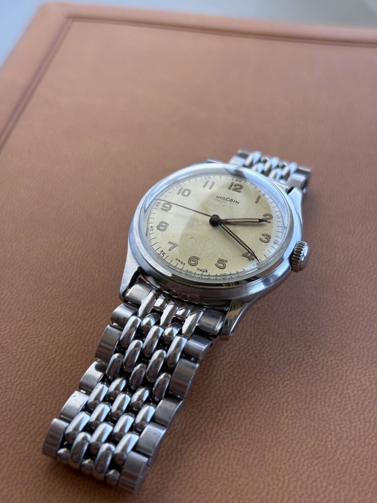 Vintage Vulcain Watch, cream and silver. Brown Background